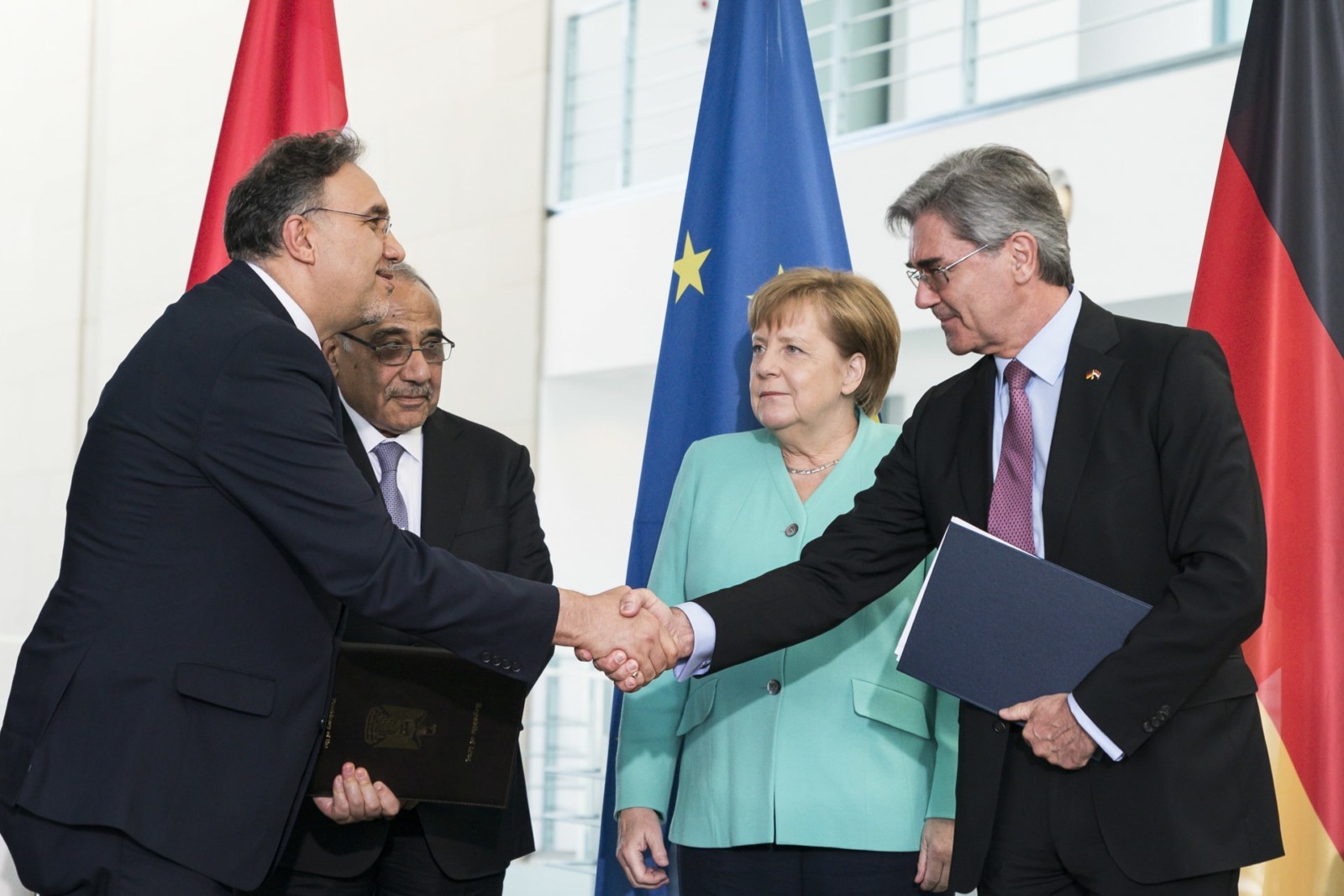 Joe Kaeser, Vorstandsvorsitzender von Siemens AG (vorne r.), und Luay Al-Khateeb, Elektrizitätsminister Iraks (vorne 2.v.l.), beim Austausch einer Umsetzungsvereinbarung zur Roadmap für die Entwicklung des Energiesektors im Irak im Bundeskanzleramt (hinten, v.l. Adel Abdul-Mahdi, Ministerpräsident Iraks; Bundeskanzlerin Angela Merkel). Foto: Bundesregierung/Kugler