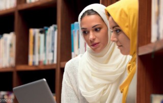 Zwei Frauen mit Hijab in einer Bibliothek