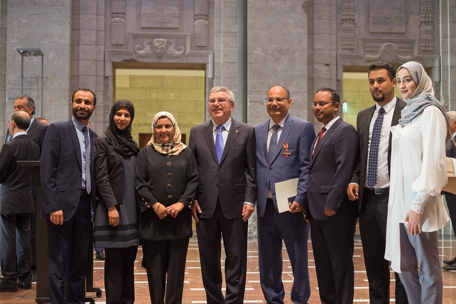 Abdulaziz Al-Mikhlafi, Generalsekretär der Ghorfa, dessen Familie, sowie Thomas Bach bei der Verleihung des Bundesverdienstkreuzes